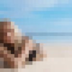 Look di trucco per l'estate abbinato a un bikini sulla spiaggia.